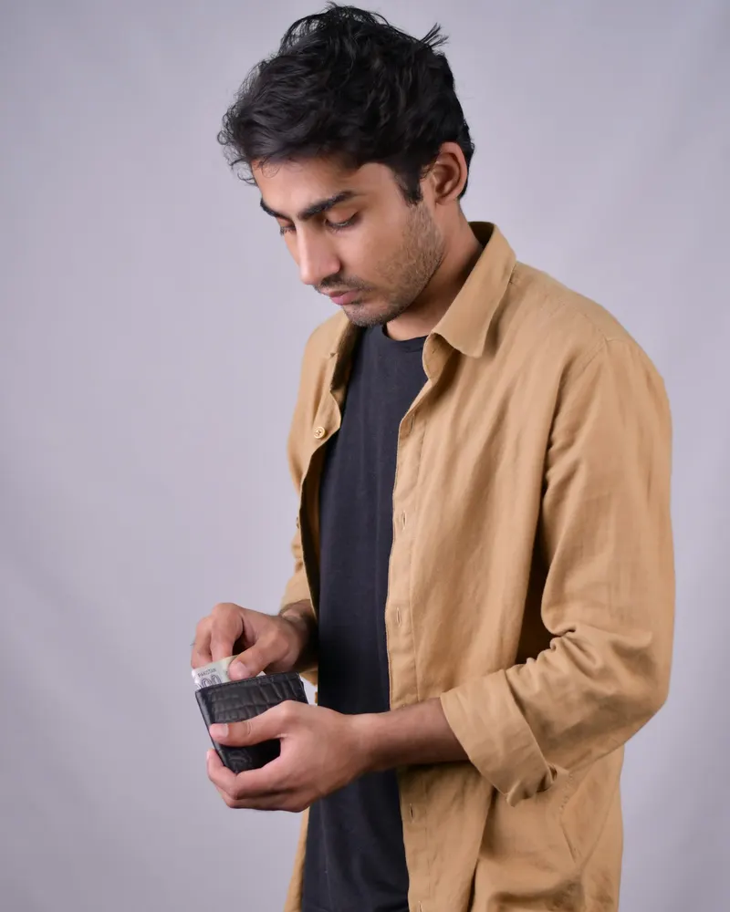 A shop owner counting money from his wallet
